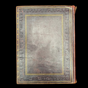 Vintage leather-bound book with decorative cover on a black background