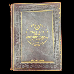 Vintage Webster's New International Dictionary on a dark background
