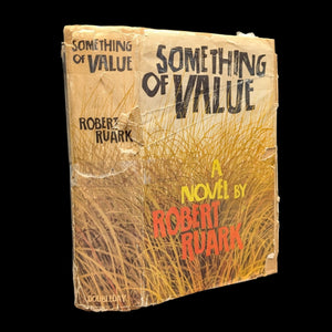 A photo of the book 'Something of Value' by Robert Ruark with a brown and gold cover, showing signs of wear and age.