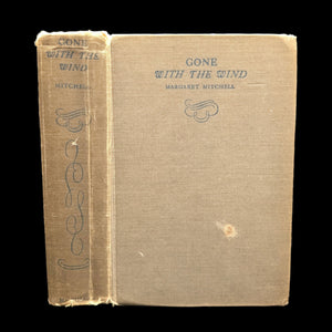 A hardcover edition of the book 'Gone With The Wind' by Margaret Mitchell with visible wear on the cover.