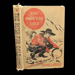 The cover of the book 'The Rush For Gold' featuring an illustration of a prospector with a dog, set against a mountainous landscape.