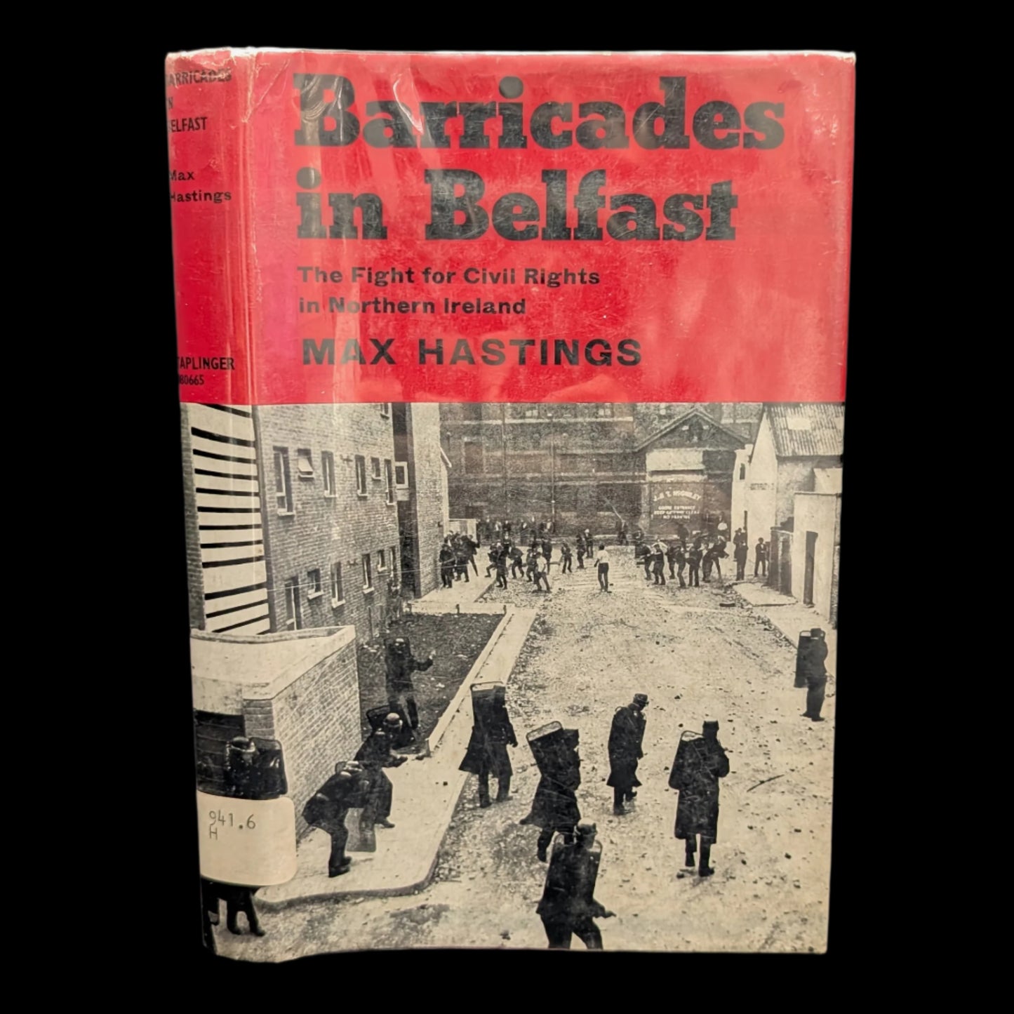 The cover of the book 'Barricades in Belfast: The Fight for Civil Rights in Northern Ireland' by Max Hastings features a black and white photograph of a street scene in Belfast with people and old buildings.