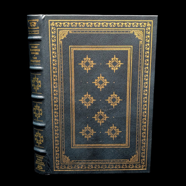 A signed first edition book titled 'The Penitent' by Isaac Bashevis Singer, featuring a black leather cover with gold embossed decorations.