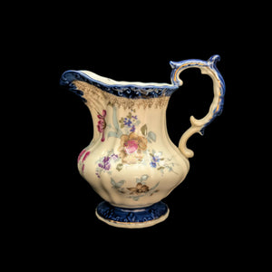 A hand-painted porcelain pitcher with blue and gold floral motifs on a white background.