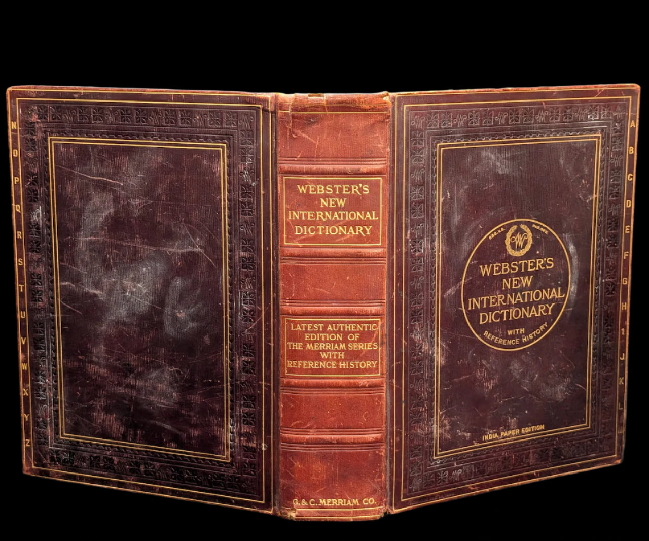 Vintage leather-bound dictionary with gold lettering on a dark background