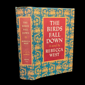 A paperback book titled 'The Birds Fall Down' by Rebecca West, with a blue and gold cover design.