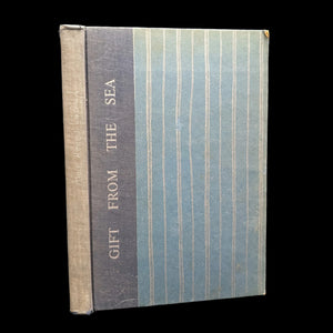 A book titled 'Gift From The Sea' by Anne Morrow Lindbergh with a blue and beige striped cover.