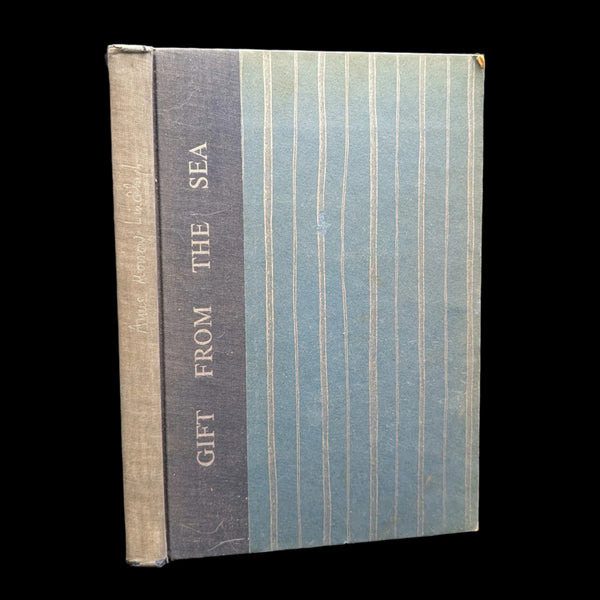 A book titled 'Gift From The Sea' by Anne Morrow Lindbergh with a blue and beige striped cover.