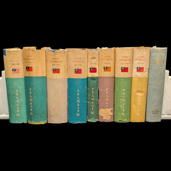 A set of nine hardcover books from the China Yearbook Collection, displaying various cover colors including blue, green, beige, and red, with Chinese characters printed on them.