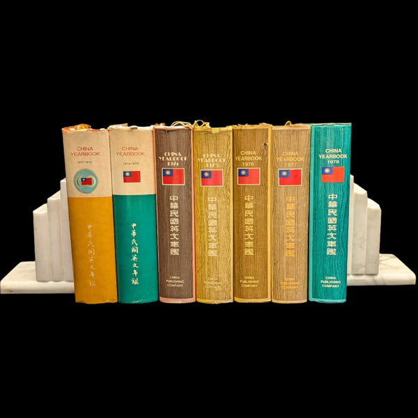 A set of seven hardcover books from the China Yearbook series, displaying various colors including green, blue, and yellow, with the Chinese flag visible on the spines.