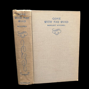 The image shows the cover of a hardcover book titled 'Gone With The Wind' by Margaret Mitchell. The book spine is visible, and the cover appears to be in a natural beige tone with decorative text and the title printed on it.