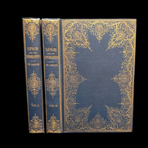 Two volumes of 'Spain And The Spaniards' by Edmondo De Amicis, with ornate gold book covers.