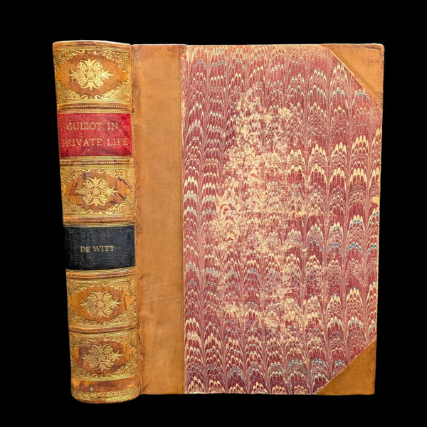 An old hardcover book with a decorative floral pattern on the inside cover and a leather binding with gold detailing on the spine.