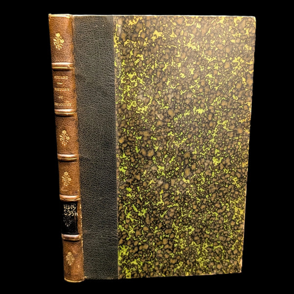 An old book with a leather and cloth binding, featuring decorative gold embossing on the spine and a speckled green and black cover.