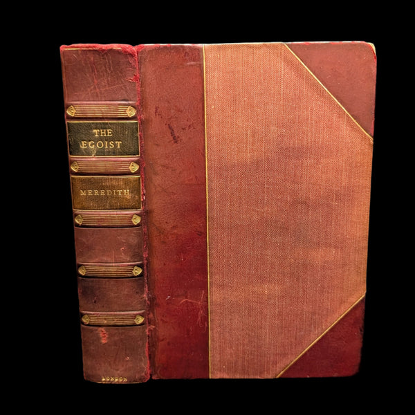 An old edition of the book 'The Egoist' by George Meredith with a red and brown cover featuring gold accents and text.