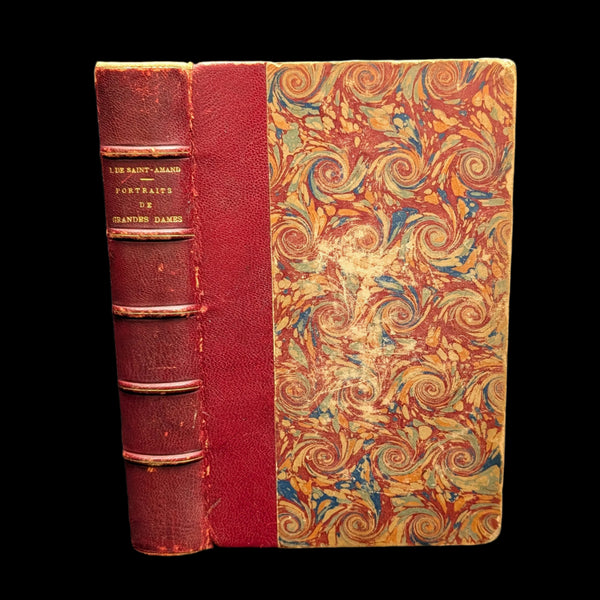 An old book with a decorative cover featuring swirls and patterns, titled 'Portraits De Grandes Dames'. The book binding appears worn with age.