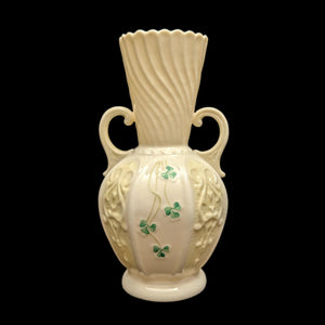 A vintage Belleek porcelain vase with a hand-painted shamrock design, primarily in white color, with green shamrocks as a detail.