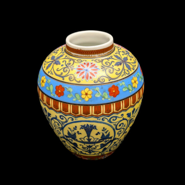 A vintage Dresden hand painted yellow vase with floral patterns, displayed against a black background.