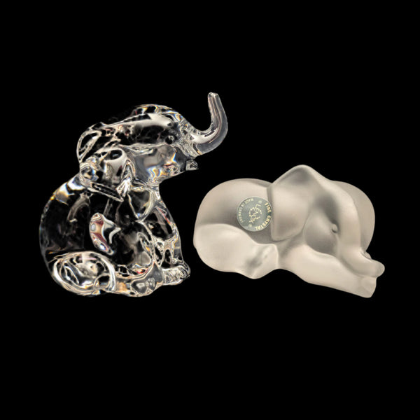 A pair of Lenox crystal elephant figurines, one clear with intricate detailing and one with a frosted appearance, against a black background.