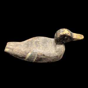 A vintage hand-carved wood duck decoy with a weathered gray body and yellow beak, displaying signs of age and use consistent with its vintage status.