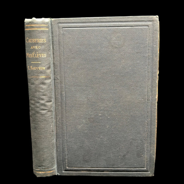 A photo of a old book with a leather cover titled 'Causeries Avec Mes Eleves, Par Lambert Sauveur, 1891'.