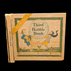 Cover of the 'Third Bubble Book, Singing Games' featuring illustrations of a man and woman with a child, with the title and author information printed on the front.