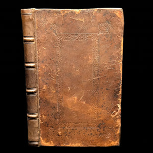 Vintage leather-bound book with intricate patterns on a gray background